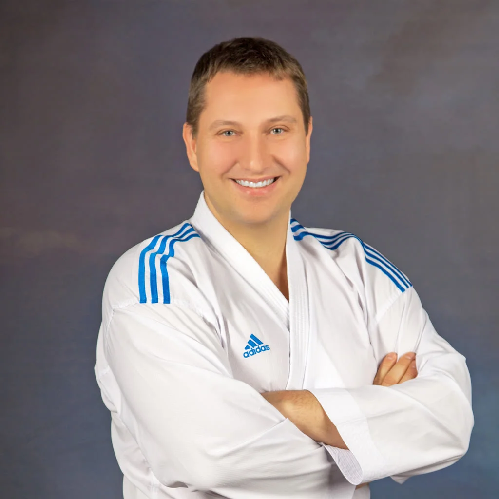 Dr. Paweł Adam Piepiora in a white karate gi with arms crossed