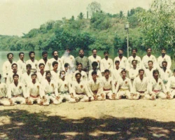 In 1984, a Karate workshop for senior Karatekas from across Kerala was conducted by Sensei P. Kuppusamy, clad in a green gi, at the Udyogamandalam Club in Kerala, India. In the photograph, I am standing second to the right of Sensei Kuppusamy. Karate workshop